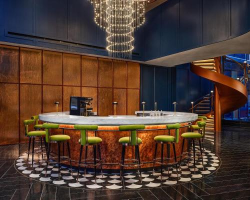 a bar with green bar stools in a room at The George At Columbia Harlem, Tapestry Collection By Hilton in New York