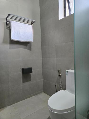 a bathroom with a white toilet and a window at Matanak 2 in Munyonyo