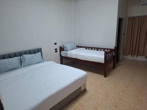 Een bed of bedden in een kamer bij Kami Guest House Patong