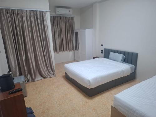 Een bed of bedden in een kamer bij Kami Guest House Patong