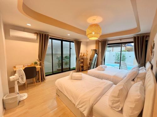 ein Schlafzimmer mit zwei Betten und einem Schreibtisch und einem Tisch in der Unterkunft New Love Is Pool Villa, Modern 3BR Pool Villa Cozy Style in Nathon Bay