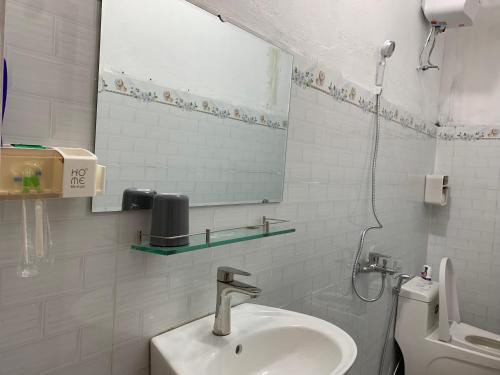 Un baño con lavabo, espejo e inodoro. en Homestay Rừng Phố 2 - Măng Đen, en Kon Plong