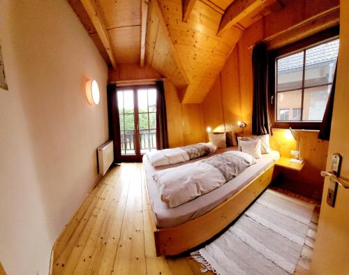 a bedroom with two beds in a wooden house at Knaller der Reiterbauernhof in Reisach