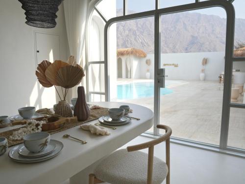 a dining room with a table and a view of a pool at Pool Villa Daya in Ras al Khaimah