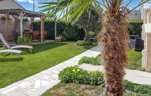 a palm tree in the middle of a yard at Charmante Maison À La Campagne in Chaintrix-Bierges