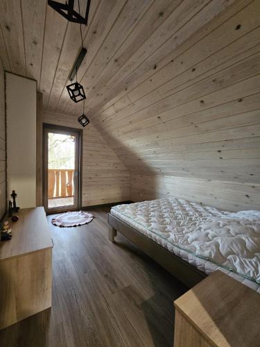 a bedroom with a bed in a wooden room at Gabrysiówka in Sztabin