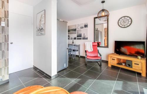 a living room with a television and a red chair at Amazing Apartment In De Haan With Wifi in Mispelburg