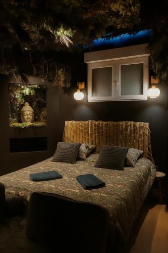 a bedroom with a bed with two monitors on it at Jungle Room Strasbourg - Évasion Tropicale - Sauna Jacuzzi Balnéo in Strasbourg