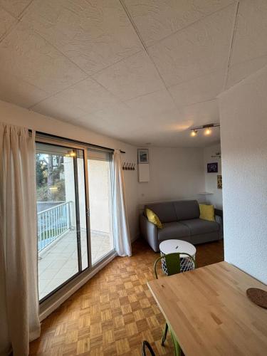a living room with a couch and a balcony at Studio lumineux - Les Angles in Les Angles