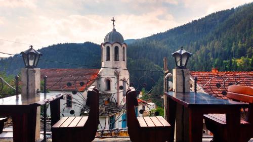 a building with a clock tower on top of it at Family hotel Valchanovata Kashta in Fotinovo