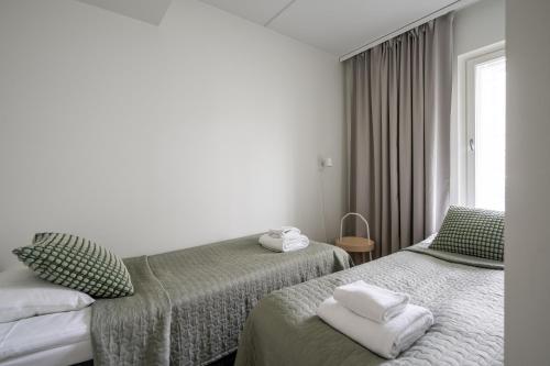 a hotel room with two beds and a window at Hiisi Homes Klaukkala in Klaukkala
