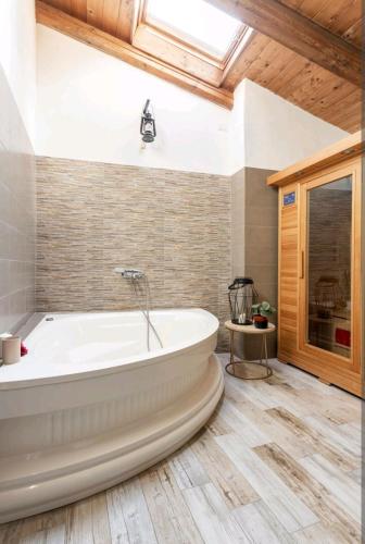 a bath tub in a bathroom with a wooden ceiling at Holiday Home Camino Monferrato in Camino
