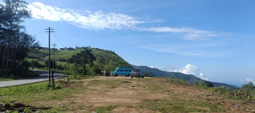 un furgone blu parcheggiato sul ciglio di una strada di Theeram holidays a Vagamon