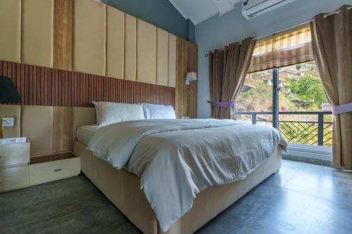 une chambre avec un grand lit et une grande fenêtre dans l'établissement Murree Hills Executive 3 Bedroom Cottage with Scenic View, à Murree
