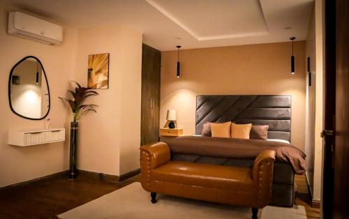 a bedroom with a bed and a leather chair at Cozy Two-Bedroom Apartment with Balcony in Islamabad