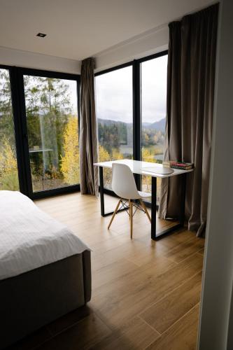 a bedroom with a bed and a table and a window at Лісогори in Slavske