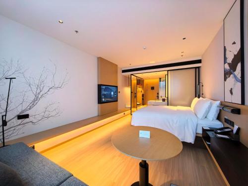 a hotel room with a bed and a couch at Fairfield by Marriott Hangzhou Future Sci-tech City in Hangzhou