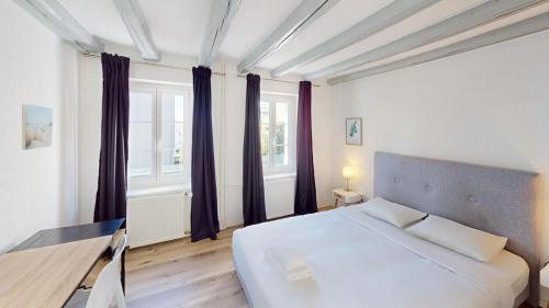 ein Schlafzimmer mit einem großen weißen Bett und Fenstern in der Unterkunft Bright & Modern 1-Bed Apt- Next to Public Transport RN18-2 in Prilly