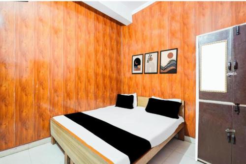 a bedroom with a bed with a wooden wall at Hotel pushpanjali in Haldwāni