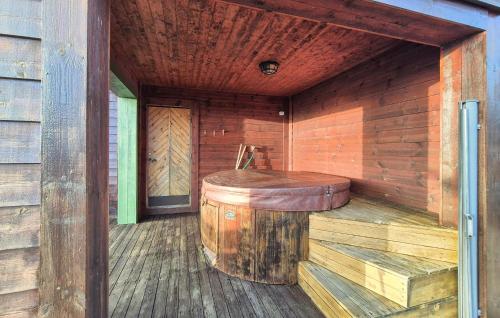 a wooden sauna with a wooden stool and a barrel at Beautiful Home In Bøvågen With Sauna in Otterholmen