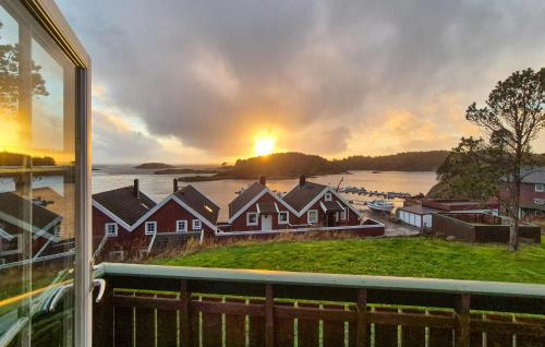 a view of a sunset from a house window at Beautiful Home In Bøvågen With Sauna in Otterholmen