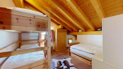 two bunk beds in a room with wooden ceilings at Abitaziun Allegra Sur DG - Zuoz in Zuoz