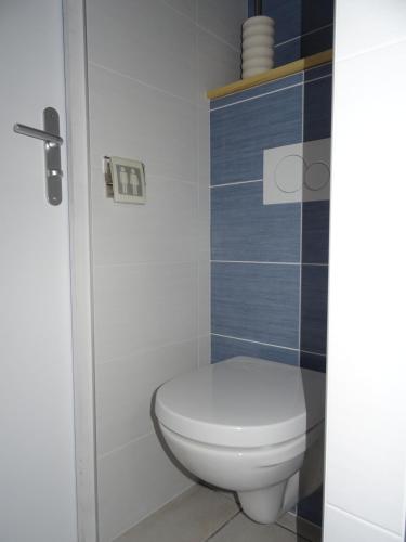 La salle de bains est pourvue de toilettes blanches et de carrelage bleu. dans l'établissement L'HERMINE - pour 2 personnes, proche de la plage, à Binic