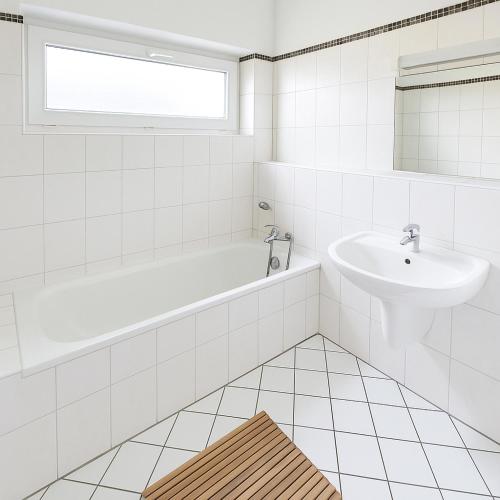 a white bathroom with a sink and a bath tub at Moderne Unterkunft in Koblenz in Koblenz