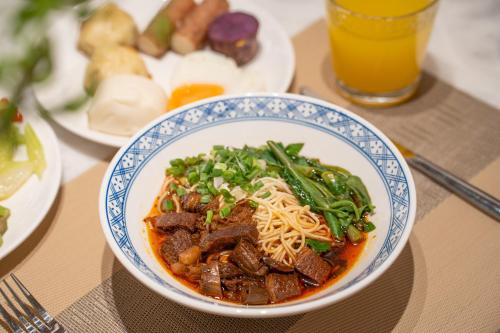 Four Points by Sheraton Chongqing في تشونغتشينغ: وعاء من الطعام على طاولة مع أطباق من الطعام