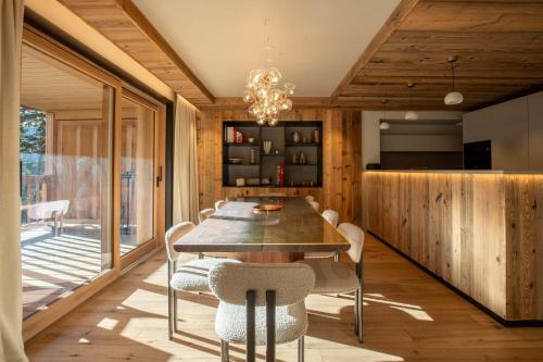 a dining room with a large wooden table and chairs at Antarès URSA 303 - luxury apartment ski inski out in Méribel