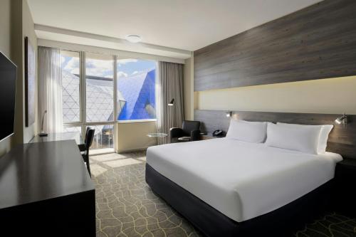 a hotel room with a white bed and a desk at Four Points by Sheraton Perth in Perth