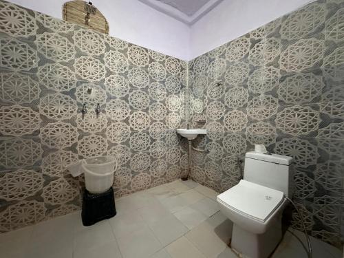 ein Bad mit einem WC und einer Wand in der Unterkunft Hotel Kota kunj Heritage in Pushkar