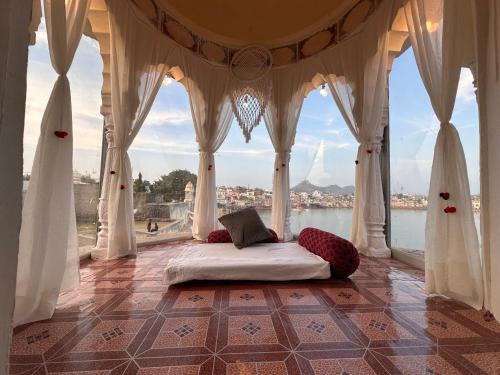 Bett in einem Zimmer mit Blick auf das Wasser in der Unterkunft Hotel Kota kunj Heritage in Pushkar