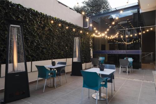 een patio met tafels, stoelen en verlichting bij Hampton by Hilton Bogota Usaquen in Bogota