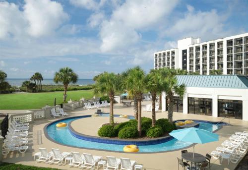 a view of the resort with chairs and a pool at DoubleTree Resort by Hilton Myrtle Beach Oceanfront in Myrtle Beach