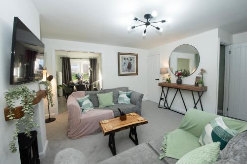 a living room with a couch and a table at Stylish 4 Bed House, Free Parking, Close to M4 Newport in Newport