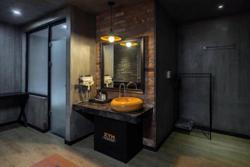 a bathroom with a sink and a brick wall at XYM Hotel Icheon in Icheon