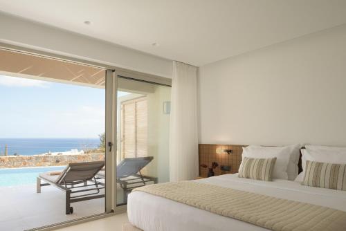 a bedroom with a bed and a view of the ocean at Galaxy Suites Boutique Resort in Hersonissos