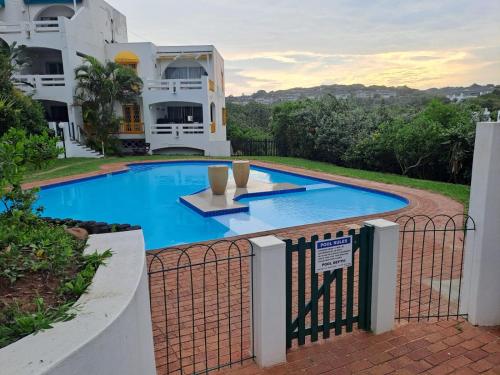 a swimming pool in front of a house at Easy Breezy at 18 Thira Santorini in Ballito
