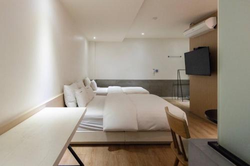 a bedroom with a large bed with white sheets at XYM Hotel Icheon in Icheon