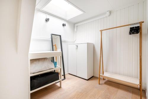 a room with a white refrigerator and a mirror at The Alkmaar Family House in Alkmaar
