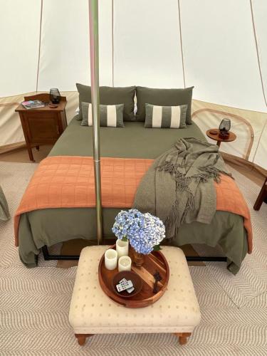 a bedroom with a bed with flowers on a table at Fairy Wren Off Grid Luxury Glamping Retreat in Wine Country in Lilydale