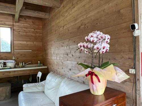 Un jarrón de flores sobre una mesa en una habitación. en Oasis Minamiboso, en Minamiboso