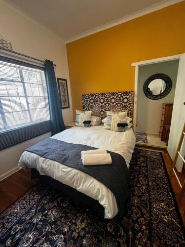 a bedroom with a large bed with a large window at Central Eclectic Studio by ARPA Hospitalities in Stellenbosch