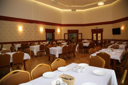 a dining room with white tables and chairs at Sanatorium Podhale in Połczyn-Zdrój