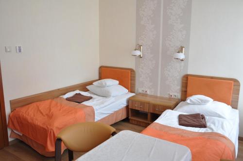 a hospital room with two beds and a chair at Sanatorium Podhale in Połczyn-Zdrój