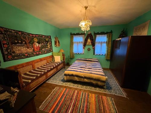 a green bedroom with a bed and a couch at Casa Verde in Lupşa