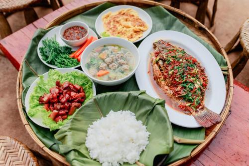 a plate of food with rice and vegetables on a table at Mae Buya Coffee Farm Stay in Ban Huai Pong Nam Ron
