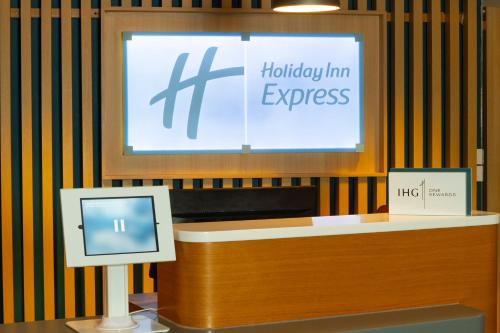 a sign that says holiday inn express and a computer at Holiday Inn Express Birmingham Airport NEC by IHG in Bickenhill