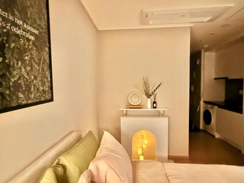 ein Wohnzimmer mit einem Sofa und einer Uhr in der Unterkunft Shine Stay 5 Min from Songdo Moonlit Festiv Park Station in Taeam